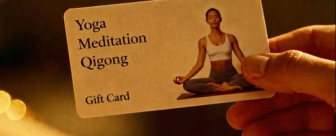 A serene hand offers a gift card with a woman in a peaceful yoga posture. "Yoga, Meditation, Qigong" shines on the left; warm light soothes the scene.